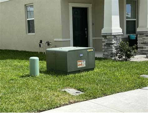 small green electrical box in yard|green box outside house.